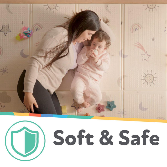 A woman kneels by a baby on the Nuby US Reversible Floor Mat | Graceful Grey, featuring stars and rainbows. An illustrated shield and "Soft & Safe" highlight the wipe-clean, portable mat’s safety.